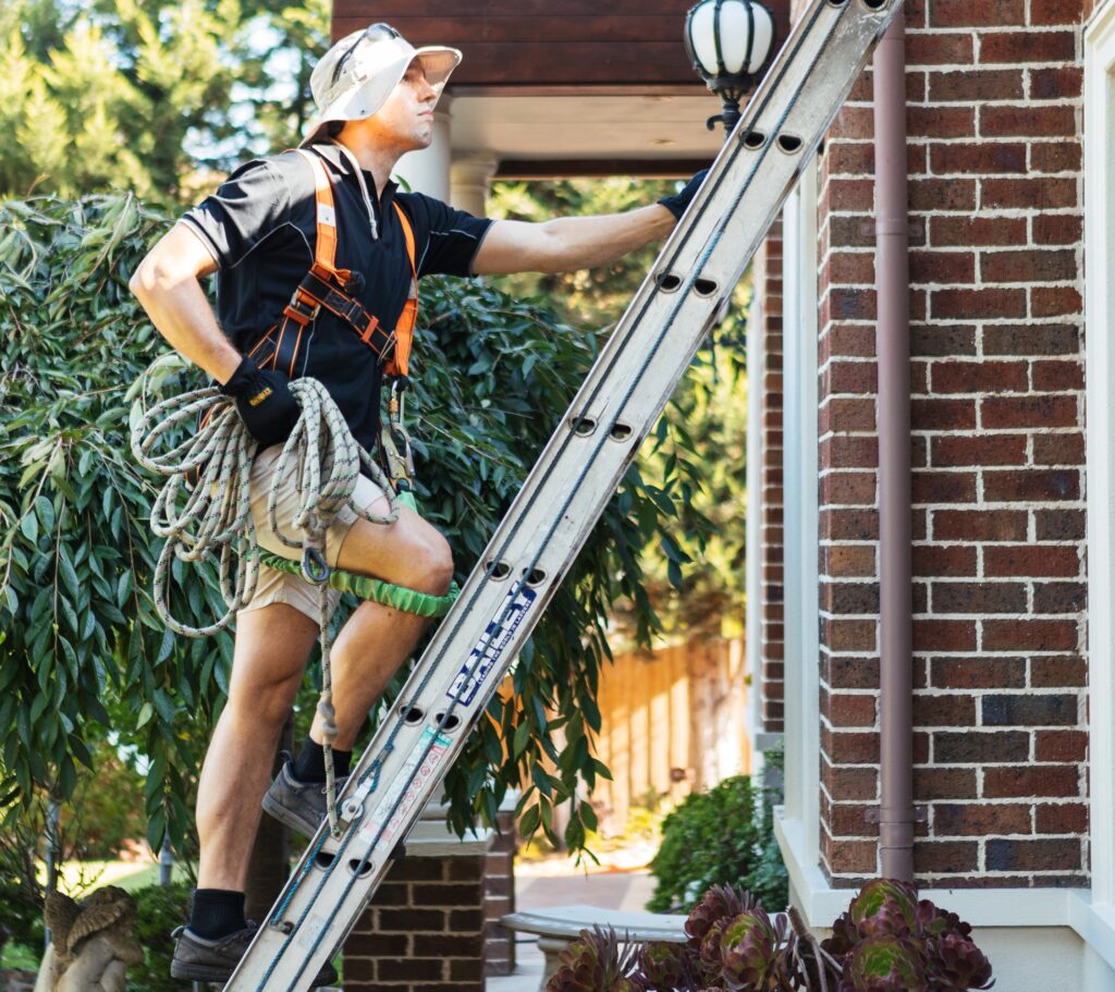 Man carrying rope up a step ladder